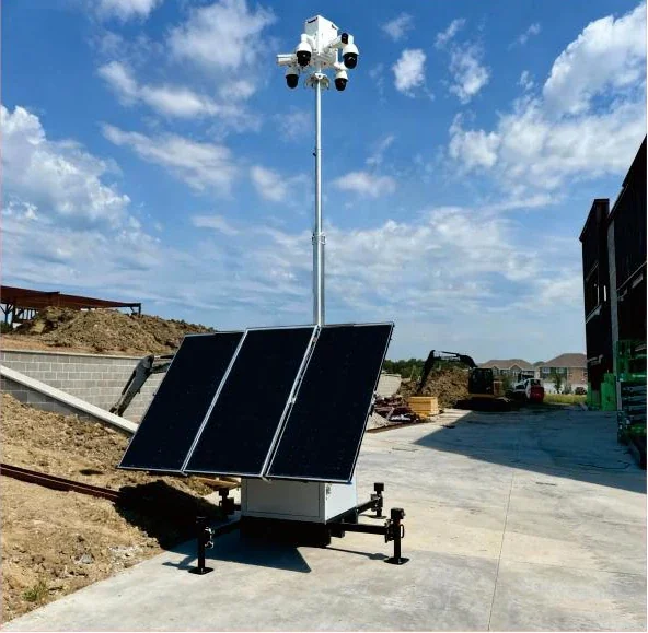 Mobile solar CCTV tower with elevated cameras and three solar panels beside a construction work area