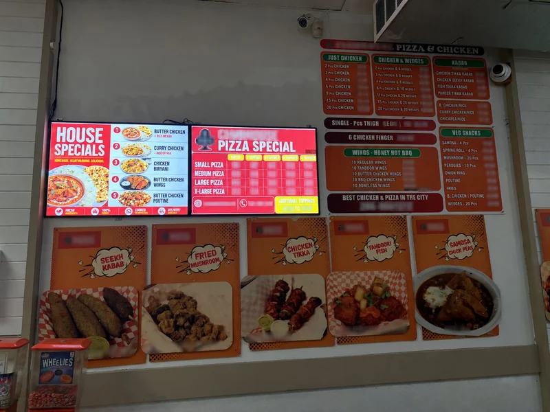 New illuminated printed menu panels on the left beside older non-backlit menu and food posters on the right and below; customer names, contact details and prices blurred