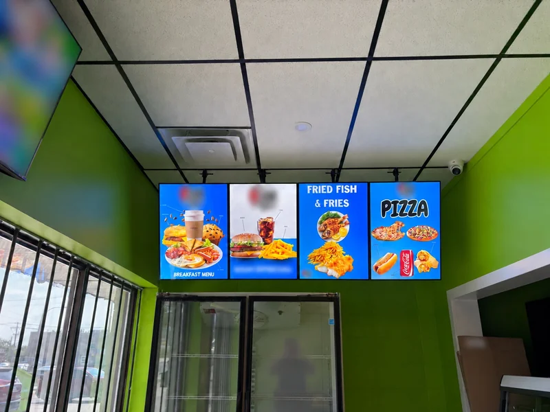Four suspended restaurant menu lightboxes in Winnipeg with customer identifiers blurred