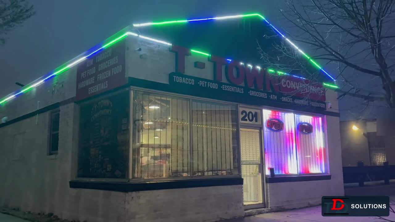 Colour-changing roofline lighting around a convenience-store building